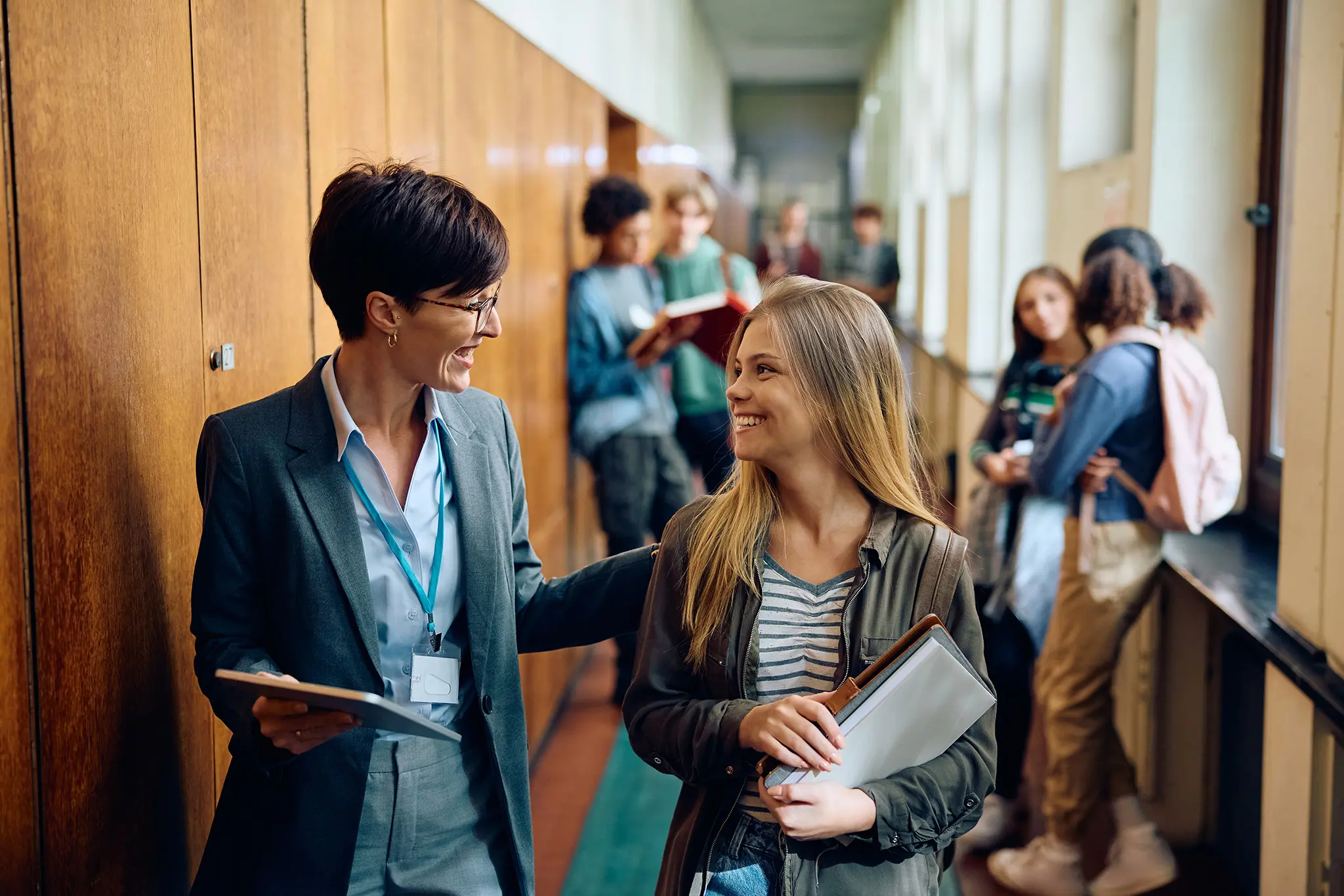 Teacher and student talking in a hall full of students